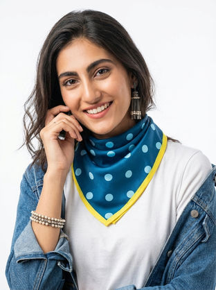 Woman wears teal polka dot satin scarf with yellow border.