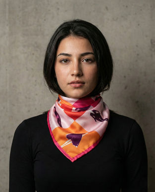 Woman wears pink and orange satin scarf around neck