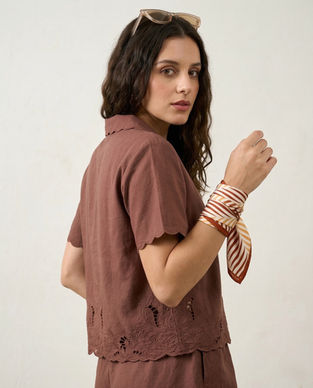 Woman wears striped satin scarf tied on wrist