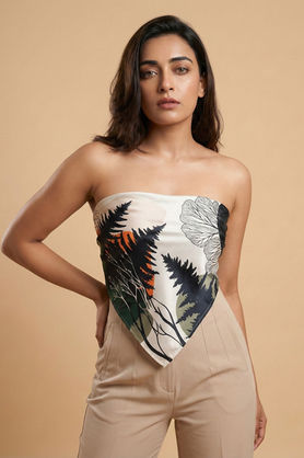 A woman wears a blue and gold abstract marble print scarf styled in a classic front bandana drape.