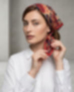 Woman wearing rust red tribal geometric square scarf as head scarf.