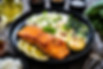 Fried salmon steak with lemon, jasmine rice and fried pak choi cabbage served on wooden ta