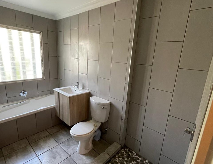 Bathroom renovation with wall-mounted toilet and designer tiling
