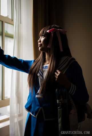cinematic portrait by hawaii photographer Grant Uchida capturing a reflective young woman gazing out the window, bathed in gentle day