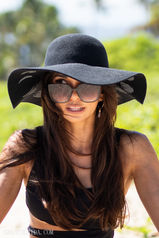 Editorial fashion portrait by hawaii photographer Grant Uchida capturing a woman in a wide-brimmed hat under tropical hawaiian sunlight, radiating effortless elegance.