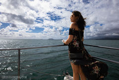 Lifestyle portrait by Hawaii photographer Grant Uchida capturing a woman on the ocean deck, the wind in her dress and the horizon ahead -  a study of calm openness