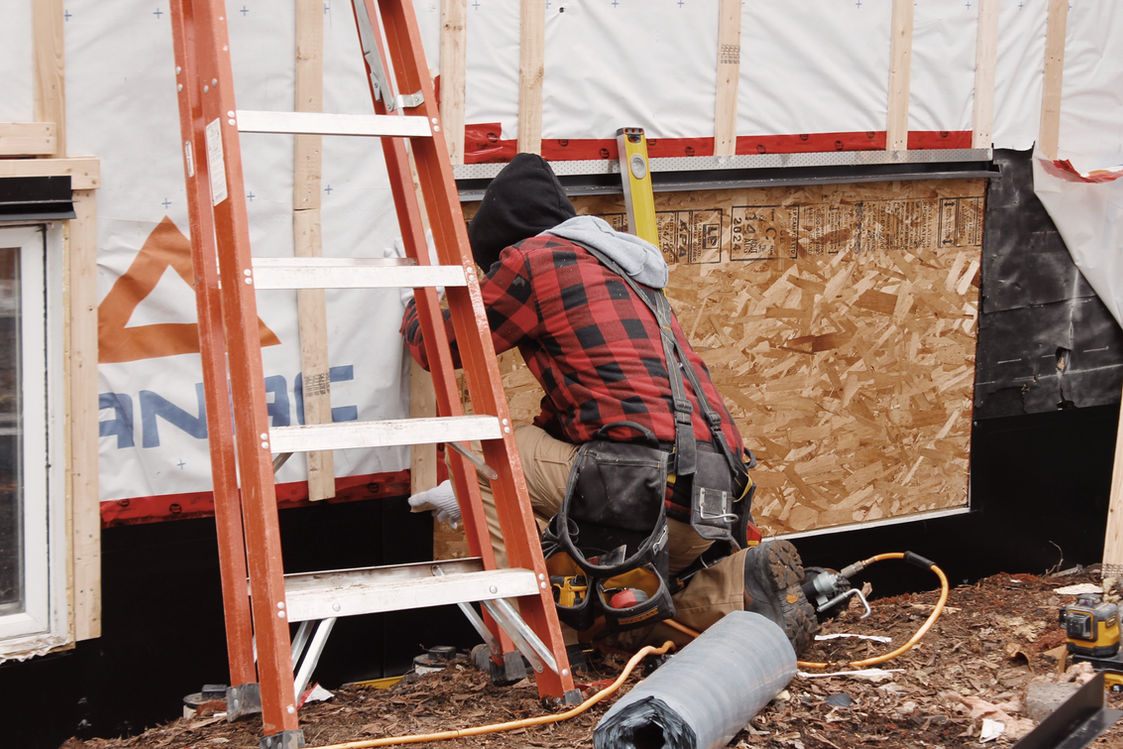 travailleur travaillant sur l'extérieur d'une maison