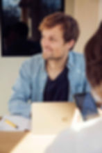 Ein Mann, welcher am Laptop arbeitet und nach draussen schaut
