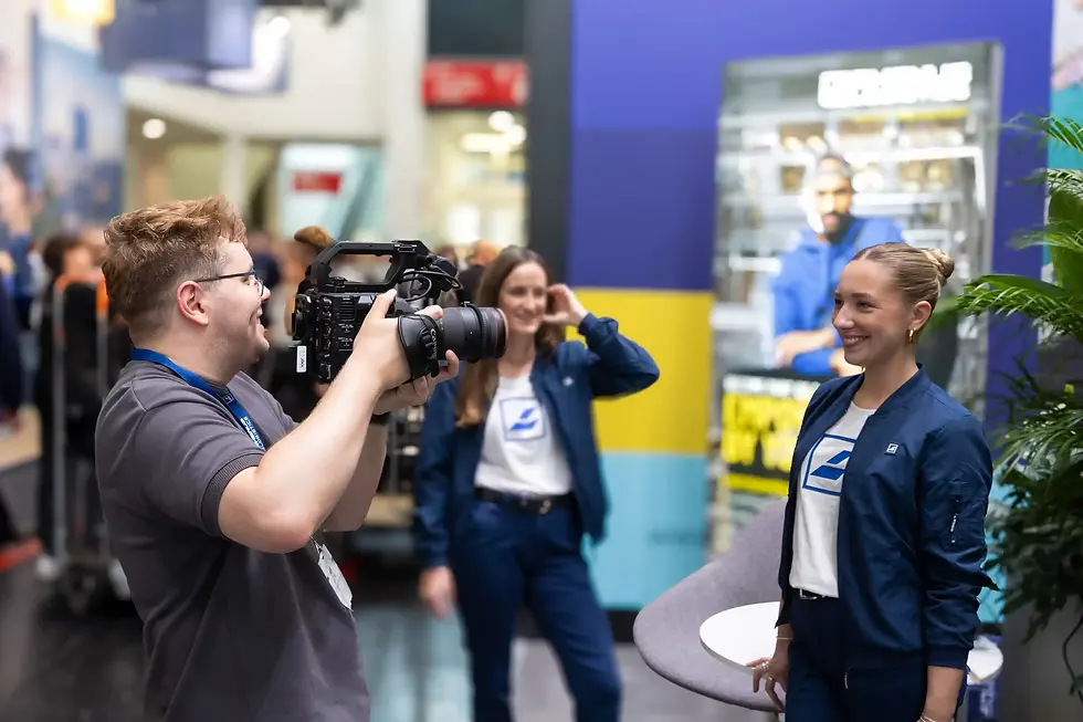 Ein Kameramann filmt ein Interview auf einer Messe