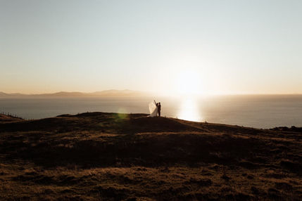 Couple silhouetted against vibrant sunset over ocean, perfect wedding venue wellington.