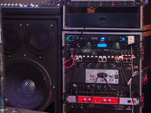 "Music producer using Suno AI interface with screens showing text prompt transforming into complete song waveform"