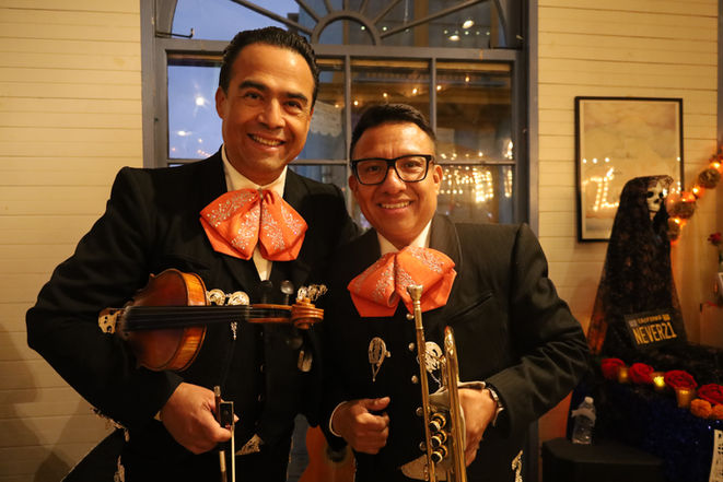 Mariachi Los Vaqueros musicians posing together with smiles after a performance in Los Angeles.
