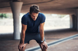 Fitness, tired and man with rest in outdoor for running challenge, exhausted or marathon t
