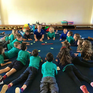 Alexander Holloway teaching children's Yoga in a school. 