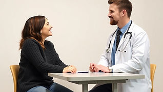 Relaxed conversation of young doctor and young patient with a desk between them.jpg