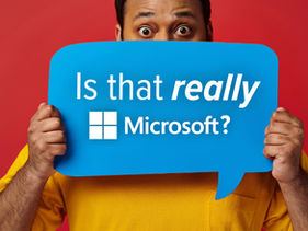 Man holding sign that says "Is that REALLY Microsoft?"