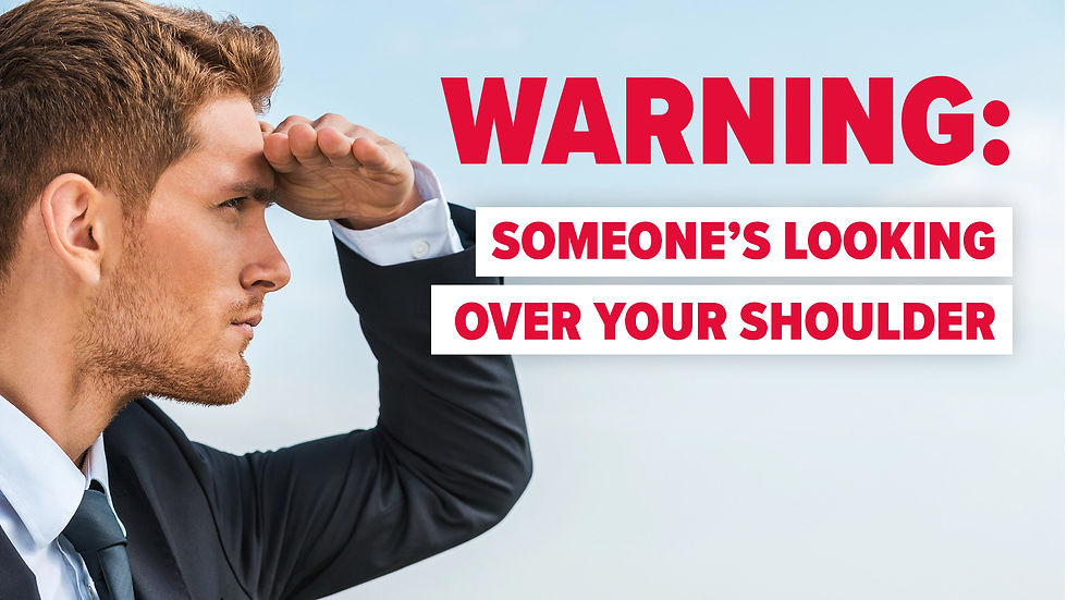 Man in suit shades eyes, looking intently left. Text in bold red: "WARNING: SOMEONE'S LOOKING OVER YOUR SHOULDER." Sky backdrop.