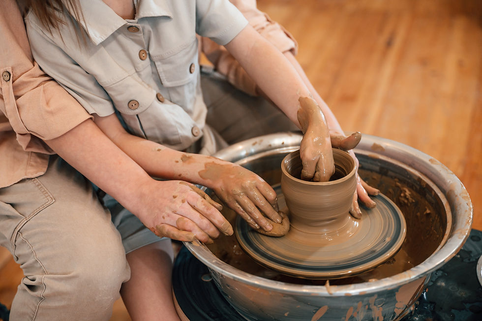 Two people making a clay ornament