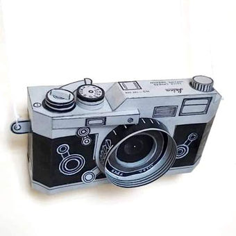 A replica of a Leica film camera is made using paper and color.