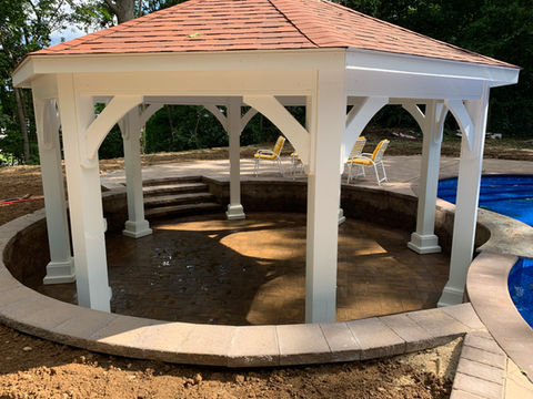 White gazebo with red roof over a patio and pool