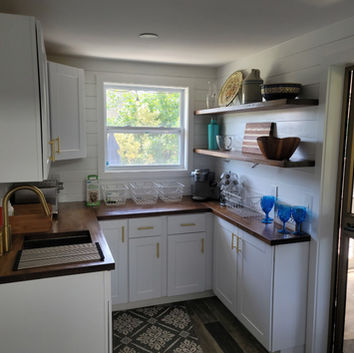 Modern kitchen with white cabinets, wood counters, open shelving