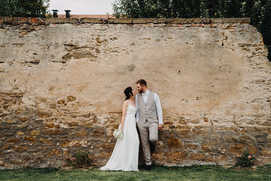 Brautpaar spaziert draußen im Garten