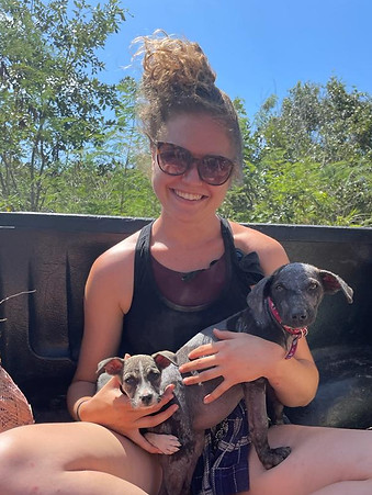 A picture of Emma Ritchie - Life and Wellness Coach with two rescued puppies in her lap