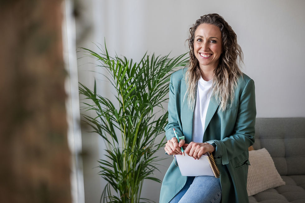 Young, graduate therapist smiling at her new client with notebook and pen in hand