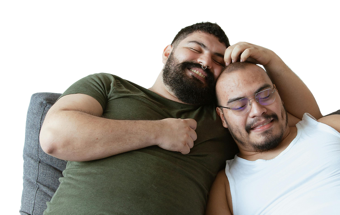 Two happy men cuddling on the couch