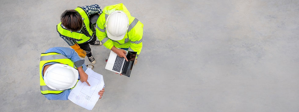 3 people in protective gear stand looking at a laptop and a paper checklist.
