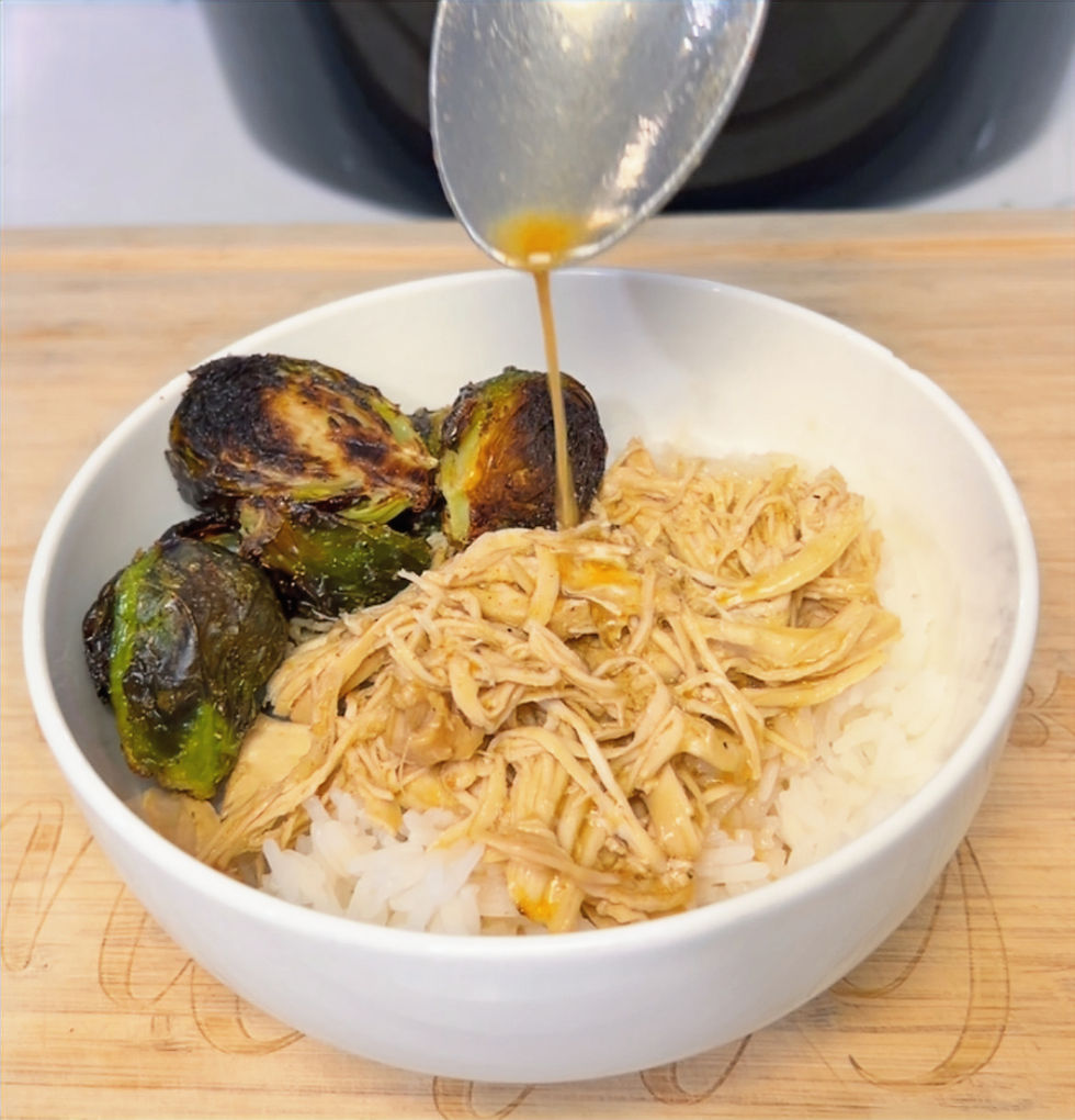 Close-up view of shredded crockpot chicken served with roasted Brussels sprouts and rice