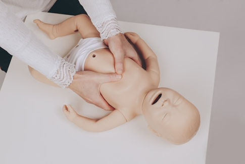 Demonstration der Herzdruckmassage bei einem Säugling