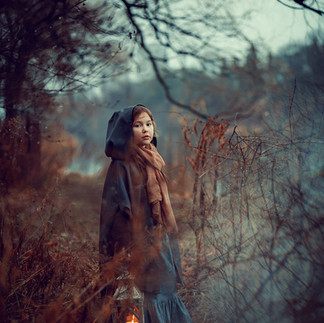 Portrait of a girl in the forest looking in the camera