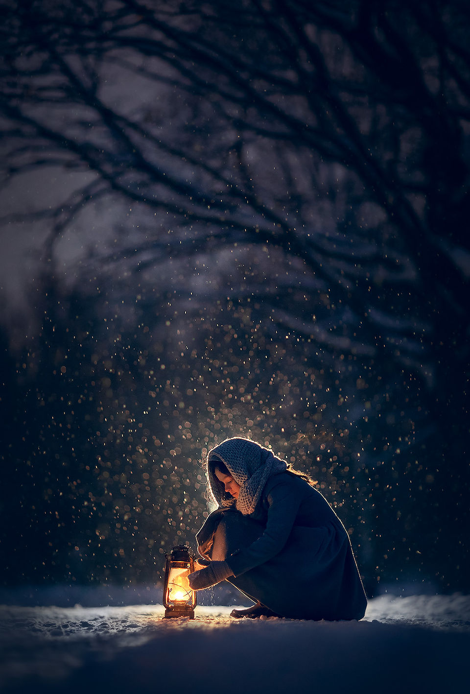 Woman with lantern in the dark snowy forest