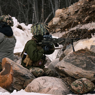Airsoft player with M249 provides cover at milsim