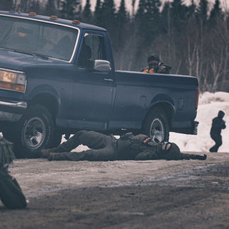 Airsoft player in road with pickup truck and smoke