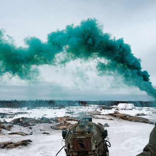 Airsoft player with green smoke grenade
