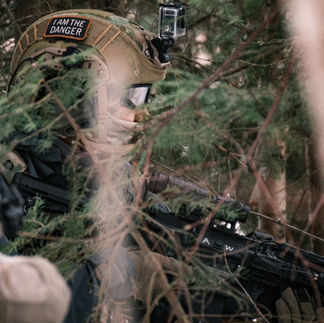 Airsoft player with rifle in trees and snow