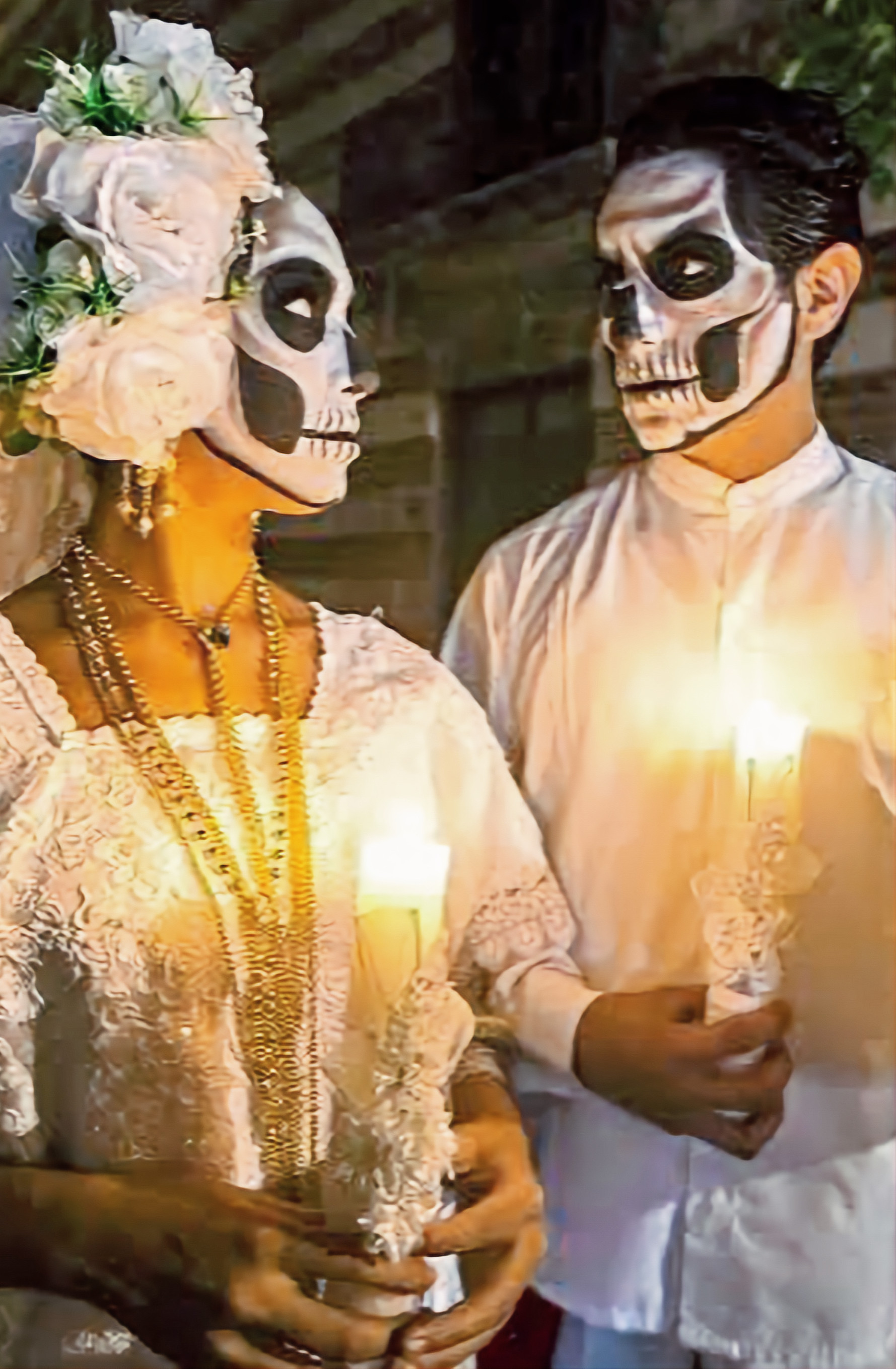 Man and woman dressed for Janal Pixán with painted faces and candles during the Paseo de las Ánimas procession in Mérida