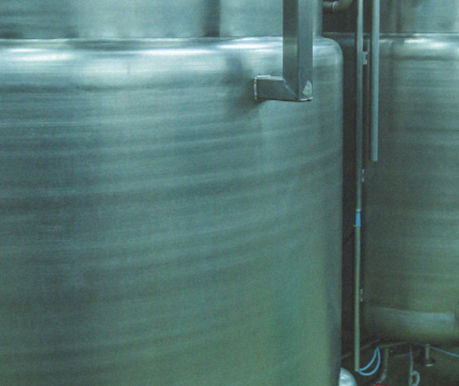 Tanques industriais em aço inox utilizados em processos sanitários, com acabamento superficial não eletropolido visível pela textura externa