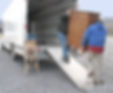 Two men carry chest of drawers onto a moving van.jpg