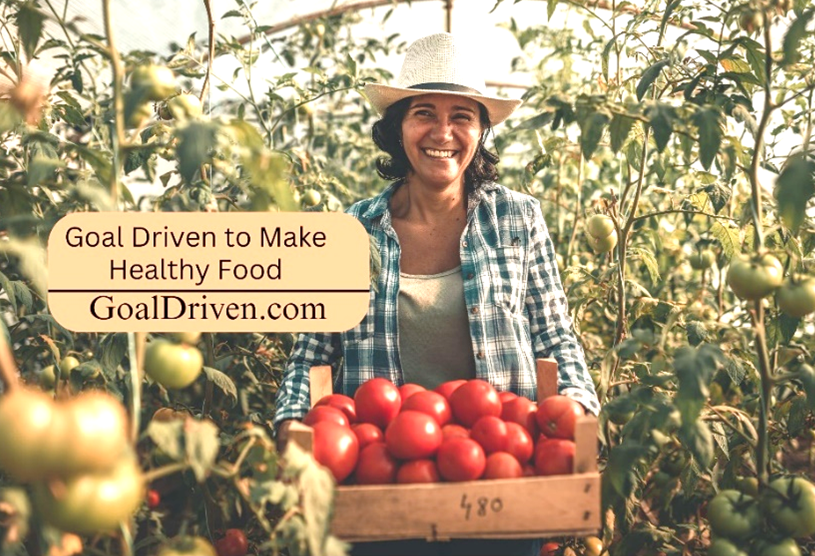 smiling female gardener with a box of fresh tomatoes