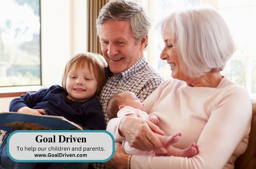 grandfather and grandmother reading a book to a toddler and coddling another