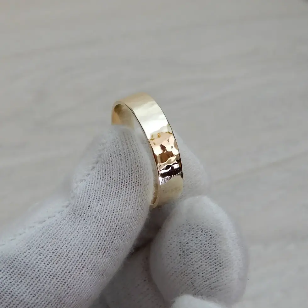 Thumbnail: Artisan-made 9ct yellow gold hammered wedding ring shown angled in hand
