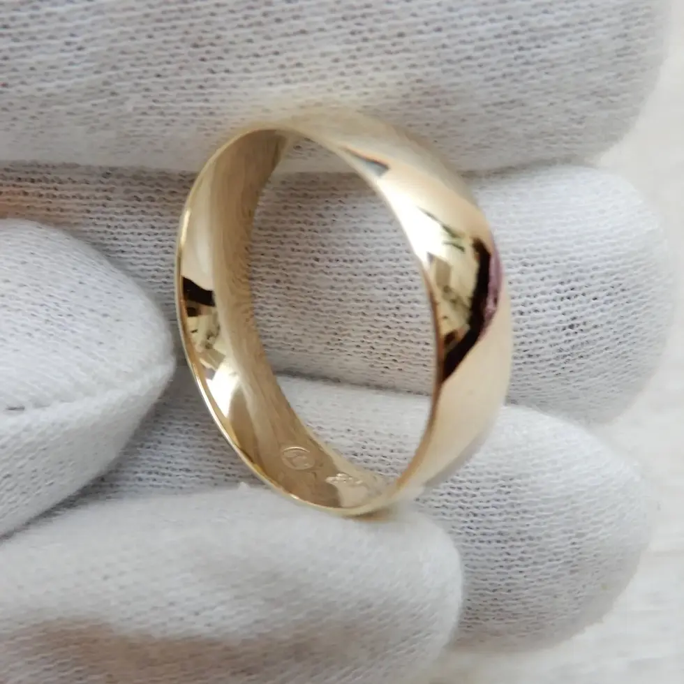 Thumbnail: Comfort fit wedding ring in polished yellow gold displayed at angle in glove