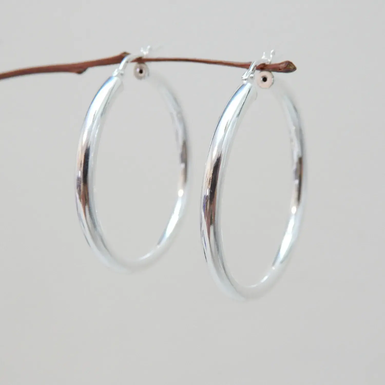 36mm sterling silver hoop earrings hanging on branch