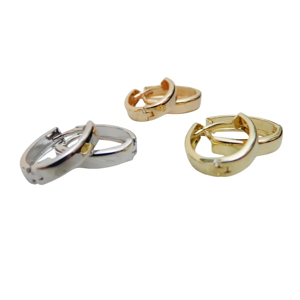 Thumbnail: Mixed gold and white gold huggie earrings arranged together