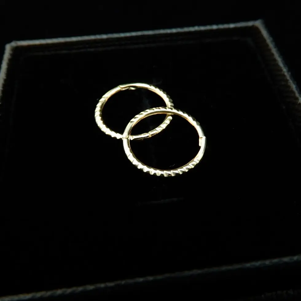 Thumbnail: Pair of 10mm twist textured yellow gold sleeper hoops shown on black surface
