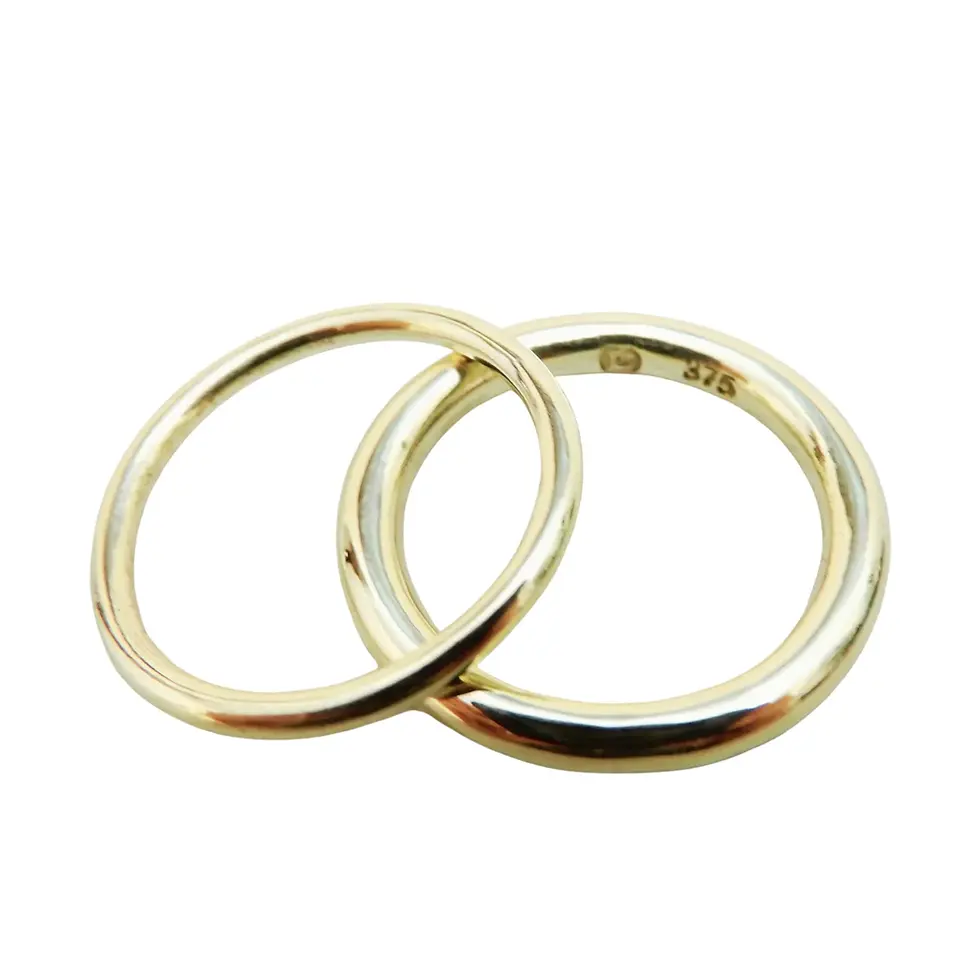 Pair of polished yellow gold round profile rings isolated on plain background