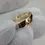 Thumbnail: Polished hammered finish yellow gold wedding band displayed close-up in glove